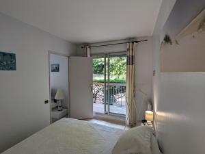 Habitación blanca con cama y ventana en Appartement Arcachon, 3 pièces, 4 personnes - FR-1-420-34, en Arcachon