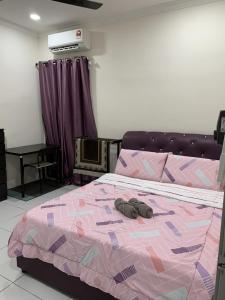 um quarto com uma cama com dois sapatos em Rosevilla Homestay - 3R2B Fully Aircond WiFi em Bandar Puncak Alam