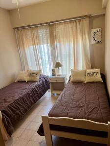 two beds in a bedroom with a window at San Clemente Ocean View in San Clemente del Tuyú +31 photos
