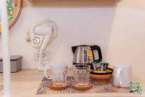 JINGLE JUNGLE RESORT KHAOYAI في مو سي: كاونتر مطبخ مع آلة صنع القهوة وكاسين زجاجي
