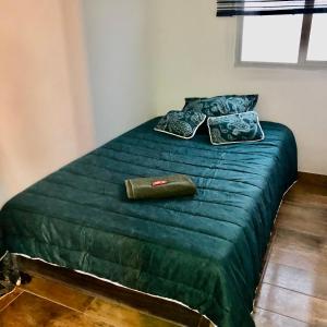 a green bed with two pillows on top of it at Apartamento zona central - paloquemao in Bogotá