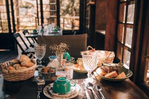 una mesa con pan y platos de comida. en Pousada Villa Serena en Campos do Jordão