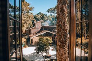 una ventana con vistas a una casa en Pousada Villa Serena, en Campos do Jordão