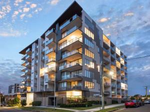 um grande edifício de apartamentos com luzes acesas em Peaceful One Bedroom Residence with Parking em Brisbane