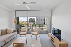 uma sala de estar com um sofá e uma mesa em Peaceful One Bedroom Residence with Parking em Brisbane