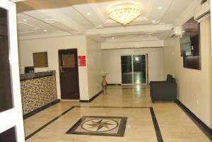 een grote lobby met een kroonluchter en een kamer bij Enclave Hotel Abuja in Kagini