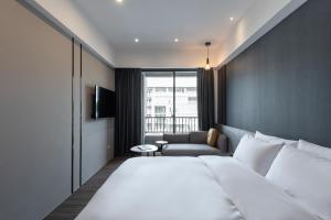 una camera d'albergo con un grande letto e un divano di Hotel Euphemia a Taichung