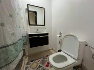 a bathroom with a toilet and a sink and a mirror at Cozy & Confort au cœur de Kenitra in Kenitra +4 photos