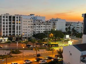 um horizonte da cidade com carros estacionados num parque de estacionamento em Cozy & Confort au cœur de Kenitra em Kenitra