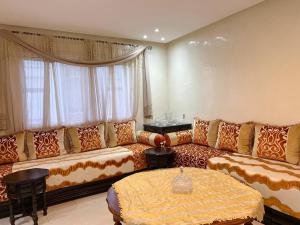 uma sala de estar com um sofá e uma mesa em Cozy & Confort au cœur de Kenitra em Kenitra