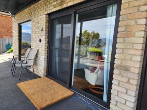 eine Glasschiebetür eines Hauses mit einer Terrasse in der Unterkunft Waterfront Abode - 2 bedrooms in Hobart