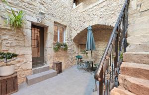 a patio with a table and an umbrella next to a building at Gorgeous Home In Bagnols-sur-cze With Kitchen in Bagnols-sur-Cèze
