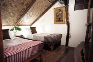 Zimmer im Dachgeschoss mit 2 Betten und einem Tisch in der Unterkunft Banahaw Circle Nature Retreat 