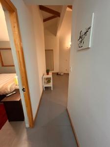 pasillo de una habitación con cama y puerta en Cabañas Altos del Simpson, en Coyhaique