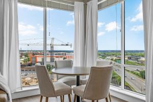 a dining room with a table and chairs and large windows at The Malibu Suite Penthouse The Gulch in Nashville