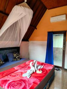 a kitten laying on a bed in a bedroom at Aladdin Homestay in Gili Islands