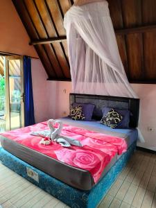 a bedroom with a bed with a canopy at Aladdin Homestay in Gili Air