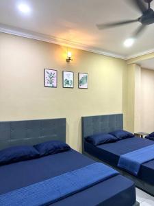 1 dormitorio con 2 camas y sábanas azules en ~Big House UITM Hospital 11 Pax~, en Shah Alam