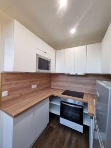 a kitchen with white cabinets and a wooden counter top at Charmant 3 pièces in Choisy-le-Roi