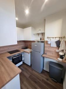 a small kitchen with white appliances and wooden floors at Charmant 3 pièces in Choisy-le-Roi