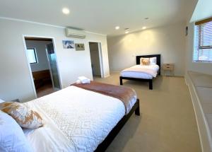 een slaapkamer met 2 bedden en een raam bij Spacious retreat with Mountain View in Rotorua