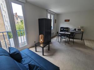 a living room with a blue couch and a table at Appartement Orléans, 2 pièces, 2 personnes - FR-1-590-362 in Orléans