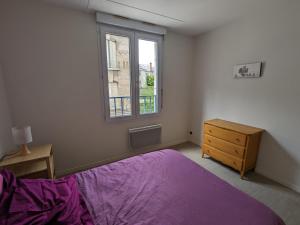 a bedroom with a purple bed and a window at Appartement Orléans, 2 pièces, 2 personnes - FR-1-590-362 in Orléans