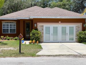 een huis met een garage en een oprit bij The Scandinavian Contemporary Goud in Lake Alfred