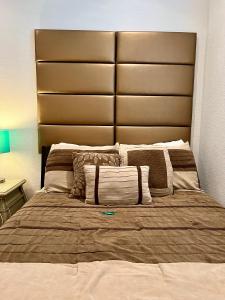 a large bed with a large headboard in a bedroom at The Scandinavian Contemporary Goud in Lake Alfred