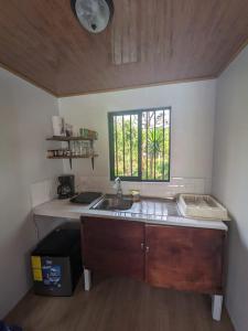a small kitchen with a sink and a window at Serenity Mountain in Poás