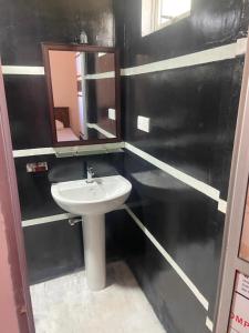 un baño con lavabo y espejo en Sandcastle Villa, en Weligama