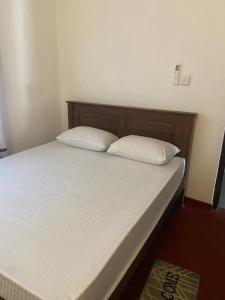 ein Bett mit zwei weißen Kissen darüber in der Unterkunft Sandcastle Villa in Weligama