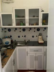 eine Küche mit weißen Schränken und einem Waschbecken in der Unterkunft Sandcastle Villa in Weligama