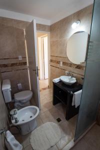 ein Badezimmer mit einem WC, einem Waschbecken und einem Spiegel in der Unterkunft Dúplex Vista Verde in Belén
