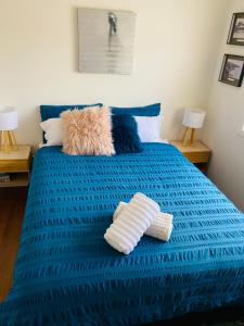 a blue bed with two pillows on top of it at Balcombe Retreat in Mount Martha