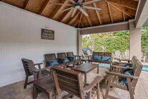 un patio con mesas y sillas de madera y techo en Island Time - Weekly Beach Rental home, en Clearwater Beach
