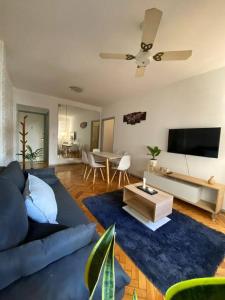 Una sala de estar con un sofá azul y un televisor en La casita de Valerio, tu lugar, en Buenos Aires