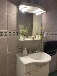 un baño con lavabo y espejo en La casita de Valerio, tu lugar, en Buenos Aires