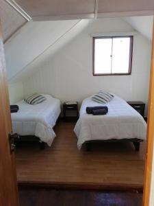 1 dormitorio con 2 camas y ventana en Alojamiento Punta Arenas en Punta Arenas