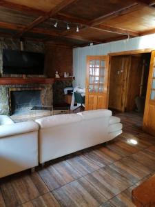 a living room with a white couch and a fireplace at Alojamiento Punta Arenas in Punta Arenas