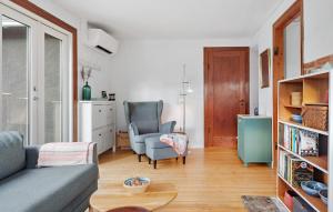 ein Wohnzimmer mit einem Sofa, einem Stuhl und einem Tisch in der Unterkunft Cozy Home In Vggerlse With Wifi in Bøtø By