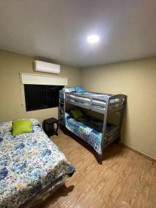 een slaapkamer met 2 stapelbedden en een raam bij Lomeli’s Home, 5 minutos del Tunco in La Libertad