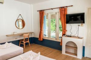 Zimmer mit einem Bett, einem TV und einem Fenster in der Unterkunft House No.2 Village in Krabi