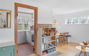 eine Küche mit einem Bücherregal und einem Tisch in der Unterkunft Cozy Home In Vggerlse With Wifi in Bøtø By