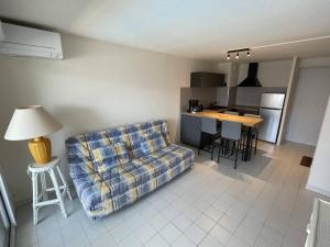 ein Wohnzimmer mit einem Sofa und einer Küche in der Unterkunft Appartement Cap d'Agde, 3 pièces, 6 personnes - FR-1-723-54 in Cap d'Agde