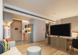 sala de estar con TV de pantalla plana grande en Home2 Suite by Hilton Chongqing South Bank en Chongqing