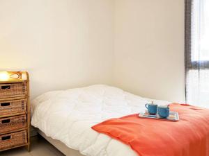 1 dormitorio con 1 cama con 2 tazas azules en una bandeja en Appartement Le Lavandou, 3 pièces, 5 personnes - FR-1-251-565, en Le Lavandou