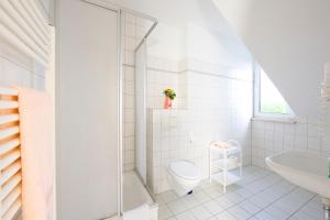 a white bathroom with a toilet and a sink at Zum Alten Schweden in Wolgast