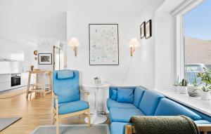 a living room with blue chairs and a blue couch at Amazing Home In Niv With Kitchen in Nivå