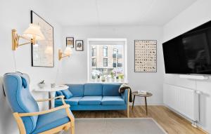 a living room with a blue couch and a tv at Amazing Home In Niv With Kitchen in Nivå